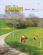 A magazine cover with two cows grazing on grass.