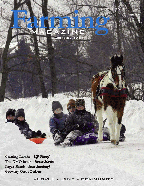 A group of people riding down the snow covered ground.