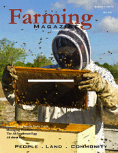 A beekeeper is holding up his hive.